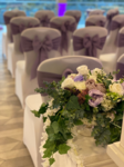 Purple bows and floral decoration down the aisle.