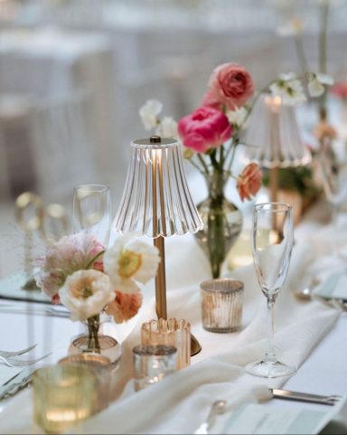 Elegant table setting with floral arrangements and soft lighting.