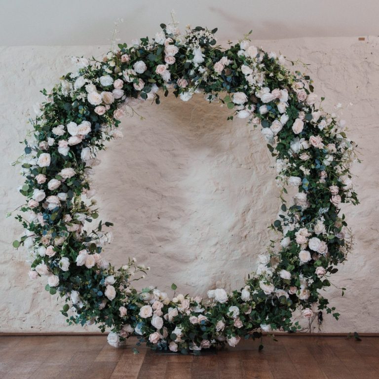 Wedding Arch Circular floral arrangement with white and pink flowers on a light background.