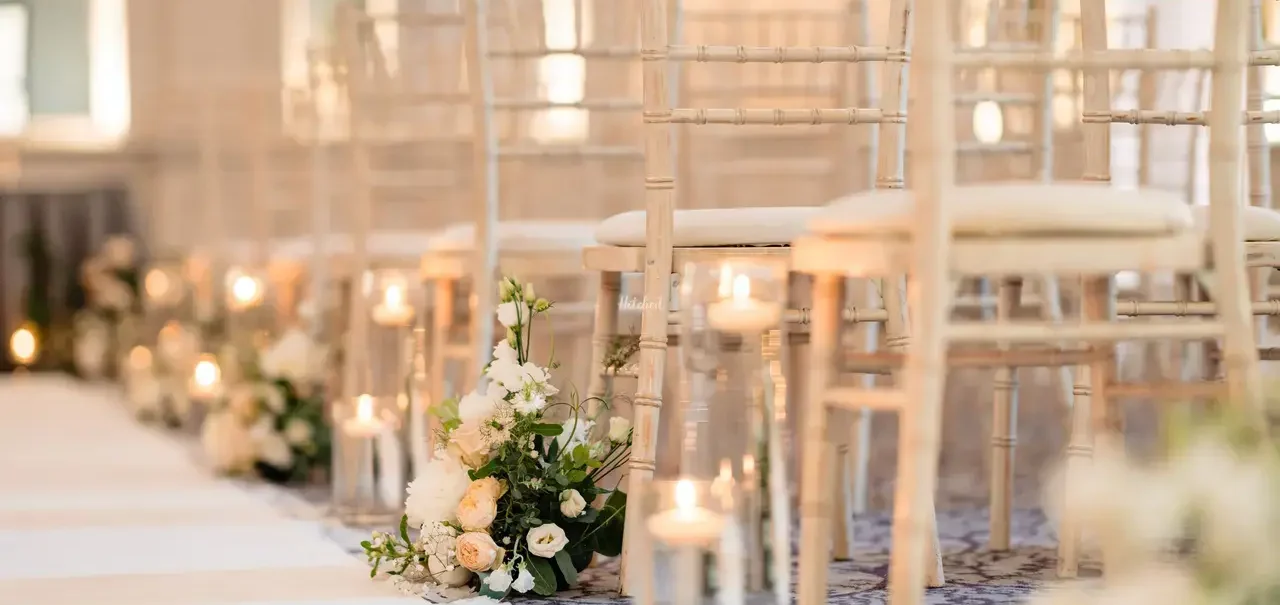 George Hotel Edinburgh Ceremony Elegant wedding setup with rows of chairs, candles, and floral arrangements.