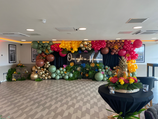Event decoration with vibrant balloons and floral arrangements in a stylish setting.